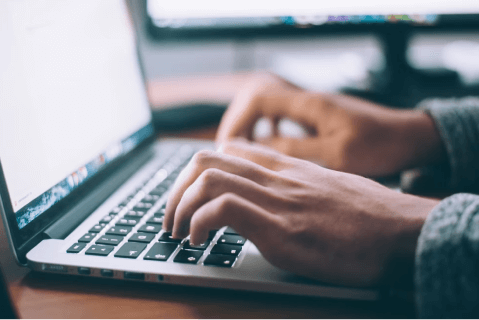 Close up of hands typing on laptop