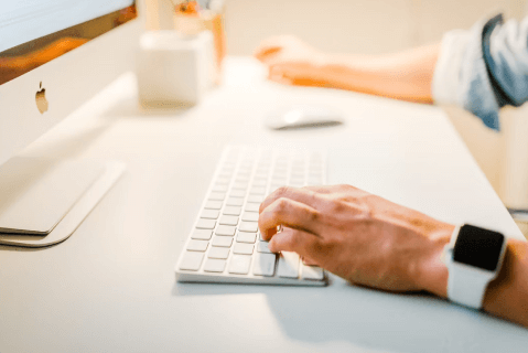 hands typing on computer keyboard